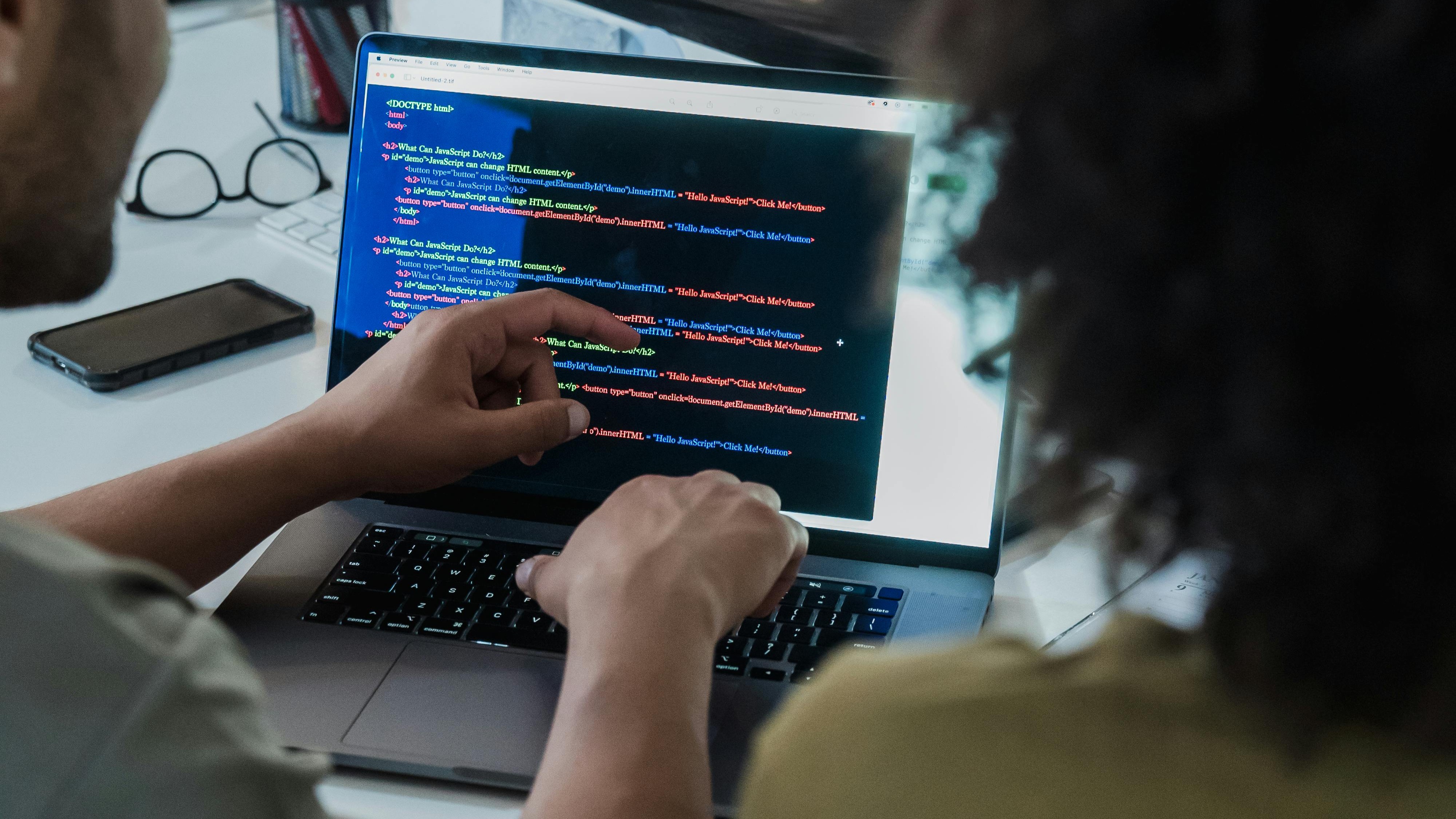 Imagem de duas pessoas trabalhando em um código juntos